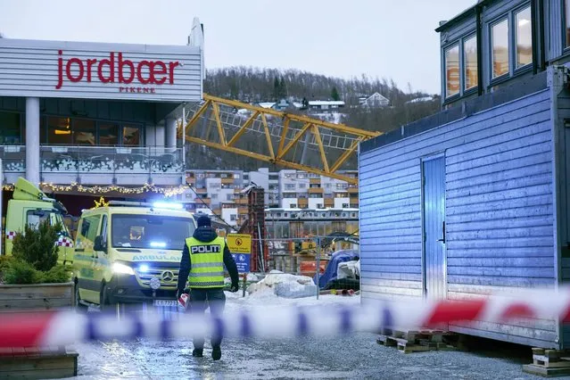 Emergency services at the scene after a construction crane fell over Melhustorget shopping mall, in Melhus, Norway, Friday, January 6, 2023. Strong winds likely have knocked over a construction crane which crashed over a shopping mall in central Norway. Police said one person was unaccounted for and at least one person was slightly injured. (Photo by Gorm Kallestad /NTB Scanpix via AP Photo)