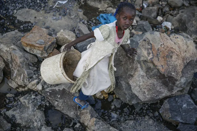 Irene Wanzila, 10, carries a bucket of broken rocks after breaking them with a hammer along with her younger brother, older sister and mother, who says she was left without a choice after she lost her cleaning job at a private school when coronavirus pandemic restrictions were imposed, at Kayole quarry in Nairobi, Kenya Tuesday, September 29, 2020. The United Nations says the COVID-19 pandemic risks significantly reducing gains made in the fight against child labor, putting millions of children at risk of being forced into exploitative and hazardous jobs, and school closures could exacerbate the problem. (Photo by Brian Inganga/AP Photo)