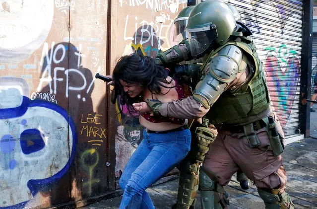 A demonstrator is detained by riot police during a protest against Chile's government in Valparaiso, Chile. October 19, 2020. (Photo by Rodrigo Garrido/Reuters)