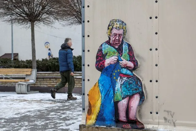 A man walks near an artwork of the famous street artist Tvboy, created on a wall of an 'invincibility centre', amid Russia's attack on Ukraine, in the town of Bucha, outside Kyiv, Ukraine on January 29, 2023. (Photo by Valentyn Ogirenko/Reuters)