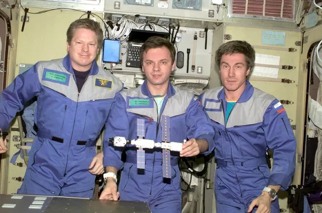 Expedition 1 crew members (L-R): Commander Bill Shepherd, Flight Engineers Sergei Krikalev and Yuri Gidzenko pose with a model of their home away from home in this November 2, 2012, NASA released file image. (Photo by Reuters/NASA)