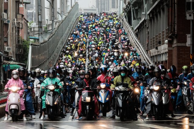 Motorcyclists wait for the light as they ride down from the exclusive motorcycle lane of the Taipei Bridge during the morning commute in Taipei on May 22, 2024. (Photo by Yasuyoshi Chiba/AFP Photo)