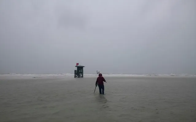 A person uses a metal detector on the beach engulfed by water before the arrival of Tropical Storm Eta in Siesta Key, Florida, U.S. November 11, 2020. (Photo by Ty Wright/Reuters)