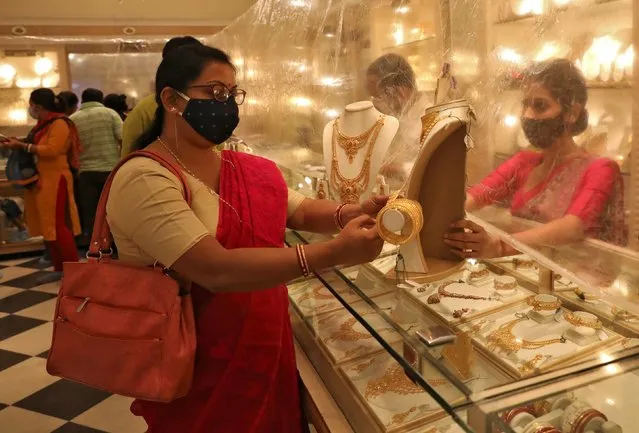 Woman looks at a gold necklace at a jewellery showroom during Dhanteras, a Hindu festival associated with Lakshmi, the goddess of wealth, amidst the spread of COVID-19 in Kolkata, India, November 13, 2020. (Photo by Rupak De Chowdhuri/Reuters)