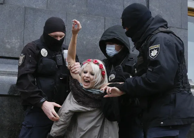 Police detain an activist from Ukrainian female rights organization “Femen” on the International Day for the Elimination of Violence against Women as she protested naked in front of the Presidential Office in Kyiv, Ukraine, Wednesday, November 25, 2020. Femen is demanding the Ukrainian authorities to ratify the Istanbul Convention on the protection of women. (Photo by Efrem Lukatsky/AP Photo)