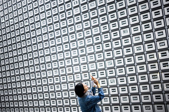 A visitor takes a picture of artwork “The World: A Moment in Time” 2024, by American artist Allan McCollum displayed at the Unlimited sector of Art Basel fair for Modern and contemporary art, in Basel, northern Switzerland, on June 11, 2024. (Photo by Valentin Flauraud/AFP Photo)