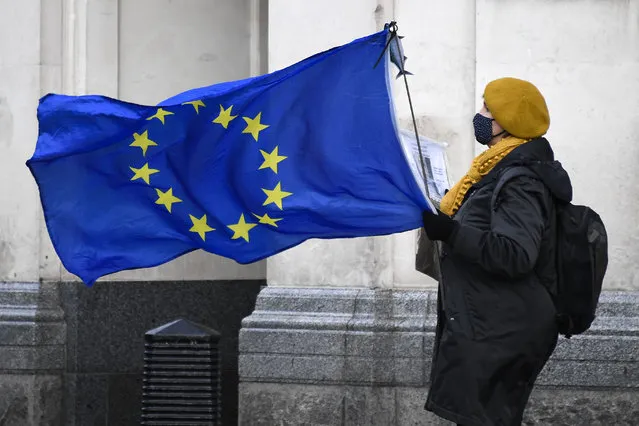 An anti-Brexit demonstrator holds an EU flag in Parliament Square, in London, Wednesday, December 16, 2020. Ursula von der Leyen said Wednesday she saw clear progress in the trade talks with the UK, turning a post-Brexit deal from a fleeting possibility into an ever more realistic possibility. (Photo by Alberto Pezzali/AP Photo)