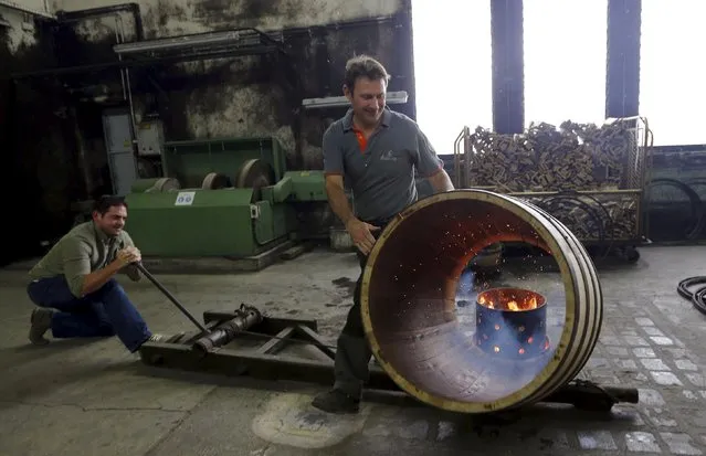 An employee works on an oak barrel in a workshop at the Hennessy factory in Cognac, southwestern France, November 5, 2015. France's centuries-old cognac houses are raising their bets on the U.S. market with new products and campaigns to broaden the drink's appeal beyond its African American stronghold. (Photo by Regis Duvignau/Reuters)