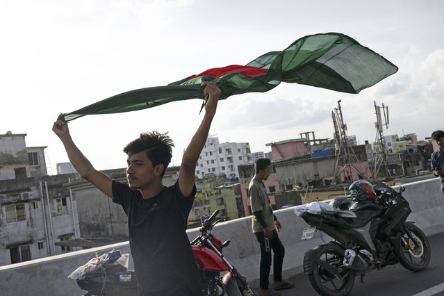A boy celebrates with a national flag after the resignation of prime minister Sheikh Hasina in Dhaka, Bangladesh, Tuesday, August 6, 2024. (Photo by Fatima Tuj Johora/AP Photo)