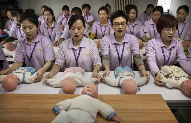 Chinese women training to be qualified nannies, known in China as ayis, learn techniqiues with plastic babies at the Ayi University on October 20, 2016 in Beijing, China. The Ayi University training program teaches childcare, early education, housekeeping, and other domestic skills. The eight-day course costs US $250, and provides successful participants with a certificate to present to prospective employers. Most of the women attending the program are migrants from villages and cities across China who have moved to the capital to earn income to send home to their own families. China's burgeoning middle class has boosted demand for domestic help in urban areas, and the need for qualified childcare is expected to grow. In 2015, the government dismantled its controversial 'one child policy' as a means of rebalancing China's aging population in order to stave off a demographic crisis. Couples are now allowed to have two children, though the availability and cost of quality childcare is cited as an obstacle for many middle class parents who want larger families. (Photo by Kevin Frayer/Getty Images)