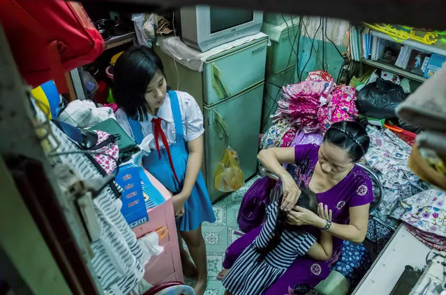 Nguyen Thi Kim Ngoc and her granddaughters are pictured in her 6.7- square- metre home in Ho Chi Minh City on May 15, 2018. (Photo by Thanh Nguyen/AFP Photo)