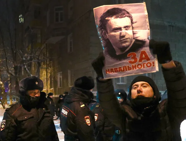 A man holds a portrait of Russian opposition activist Alexei Navalny outside the 2nd Department of the Russian Interior Ministry Directorate for Khimki in Moscow Region, Russia on January 18, 2021, where Navalny is held after his detention upon arrival at Sheremetyevo International Airport on January 17. The Khimki City Court has put Navalny in custody until February 15. (Photo by Sergei Bobylev/TASS)