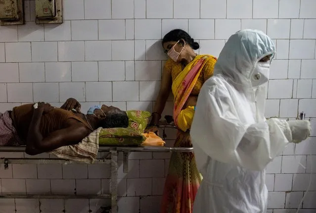 A woman leans against a stretcher holding her husband in the corridor of the emergency ward of Jawahar Lal Nehru Medical College and Hospital, during the coronavirus disease (COVID-19) outbreak, in Bhagalpur, in the eastern state of Bihar, India, July 27, 2020. (Photo by Danish Siddiqui/Reuters)