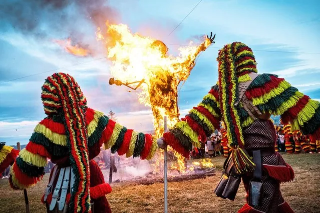 “Caretos” performs religious rituals during the burning of a giant Careto in Podence, Portugal on March 1, 2022. The ancient Carnival (Entrudo) held in the village of Podence is one of the most important traditional events of northern Portugal. During the celebration, diabolical figures called Caretos roam the streets of Podence, making noise with the rattles they wear around their waists. The festival ends with the burning of a giant Careto. (Photo by Hugo Amaral/SOPA Images/LightRocket via Getty Images)