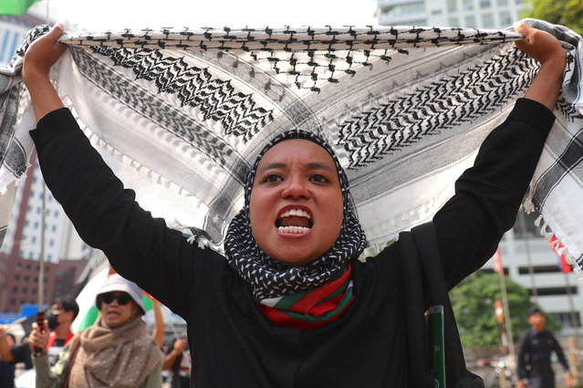 A protester holds a keffiyeh scarf while walking towards the US embassy during a protest against the US and Israel in Kuala Lumpur, Malaysia, 26 September 2025. The protest was staged to demand affirmation of the right to life of the Palestinian people. (Photo by Fazry Ismail/EPA)