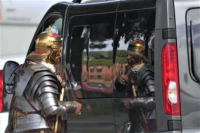 A man wearing a Roman Centurion costume uses the windshield of a car as a mirror prior to the start of a historical parade at Circus Maximus to celebrate Rome's birthday, Sunday, April 23, 2023. On Friday April 21, Rome celebrated the 2776th anniversary of its legendary foundation by Romulus in 753 BC. The annual birthday celebration, called in ancient times “Dies Romana” or “Romaia”, includes historical re-enactments of ancient Roman rituals, costumed parades, and gladiator fights, staged by the Rome Historical Group in the Circus Maximus. (Photo by Gregorio Borgia/AP Photo)