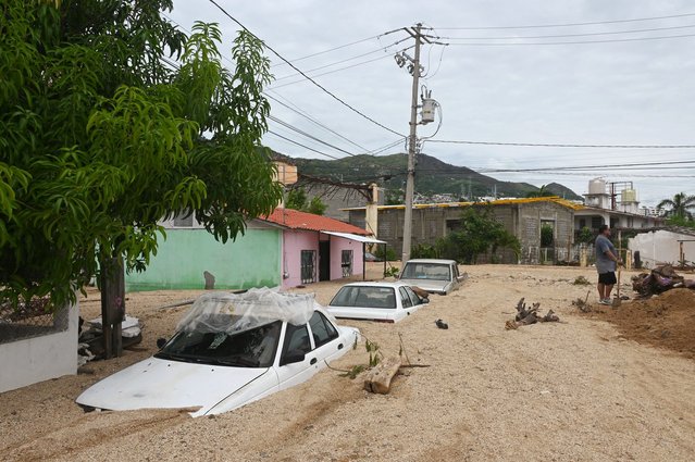 Cars covered in sand are pictured following Hurricane John in Acapulco, Guerrero State, Mexico, on September 29, 2024. The death toll from Hurricane John, which made landfall twice on Mexico's Pacific coast, rose to 16 by September 29, authorities said. (Photo by Francisco Robles/AFP Photo)