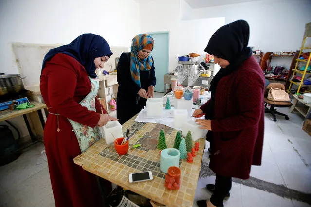 Palestinian women use wax to make decorative objects in the West Bank town of Dura, south of Hebron November 17, 2016. (Photo by Mussa Qawasma/Reuters)