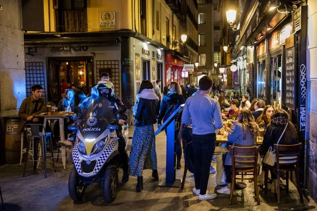 Policeman patrols in downtown Madrid, Spain, Friday, March 26, 2021. With its policy of open bars and restaurants — indoors and outdoors — and by keeping museums and theaters running even when outbreaks have strained hospitals, Madrid has built a reputation as an oasis of fun in Europe’s desert of restrictions. Other Spanish regions have a stricter approach to entertainment. Even sunny coastal resorts offer a limited range of options for the few visitors that started to arrive, coinciding with Easter week, amid a set of contradictory European travel rules. (Photo by Bernat Armangue/AP Photo)