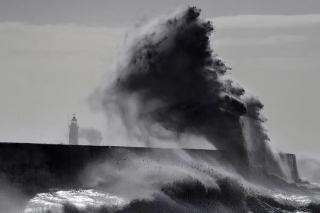 Waves crash over the harbour wall in Newhaven, south coast of England on March 11, 2021 as heavy gusts hit the south coast. (Photo by Glyn Kirk/AFP Photo)