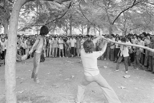 In this October 6, 1976, file photo, a member of a Thai political faction strikes at the lifeless body of a hanged student during a student massacre outside Thammasat University in Bangkok. This year’s anti-government protests  are seeking new elections, a more democratic constitution and an end to intimidation of political activists. Their speeches have repeatedly highlighted the 1976 tragedy, piquing the interest of the current generation in what their forebears faced. (Photo by Neal Ulevich/AP Photo/File)