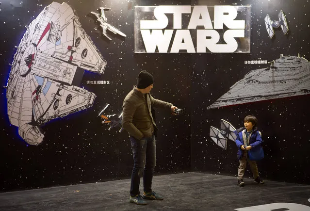 A man takes a smartphone photo of his son at a "Star Wars" promotional display at a shopping mall in Beijing, Saturday, January 9, 2016. (Photo by Mark Schiefelbein/AP Photo)