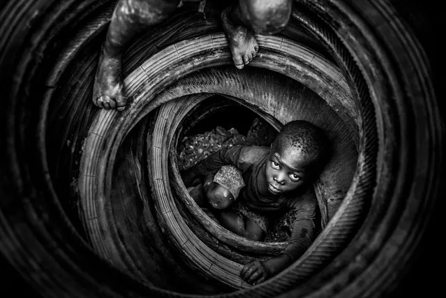 Boulmigou: The Paradise of Forgotten Hearts by Antonio Aragón Renuncio, highly commended photographer of the year. Children play with old tyres that will eventually be burned, warming the rock beneath and making it more brittle in the polluted Boulmigou quarry in Ouagadougou, Burkina Faso. The consequences are terrible: fires, respiratory diseases, groundwater contamination and even death. (Photo by Antonio Aragón Renuncio/2018 Ciwem environmental photographer of the year 2018)
