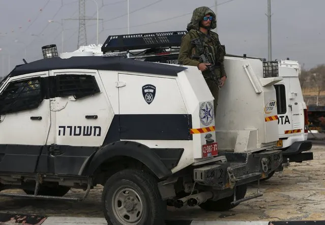 An Israeli soldier stands guard near the scene where a Palestinian, who the Israeli military said tried to stab an Israeli soldier, was killed by Israeli troops, near the West Bank city of Hebron January 14, 2016. (Photo by Mussa Qawasma/Reuters)