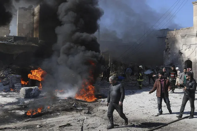 Civil defence members try to put out a fire as residents inspect the damage at a site hit by what activists said was a barrel bomb dropped by forces loyal to Syria's President Bashar al-Assad in the Qadi Askar neighbourhood of Aleppo March 5, 2015. REUTERS/Abdalrhman Ismail (SYRIA - Tags: CIVIL UNREST POLITICS CONFLICT TPX IMAGES OF THE DAY)