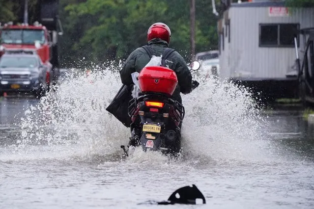 A man rides a motorcycle through flooded streets in the Hole, one of the lowest neighborhoods in the Brooklyn borough of New York City, U.S., September 29, 2023. (Photo by Bing Guan/Reuters)