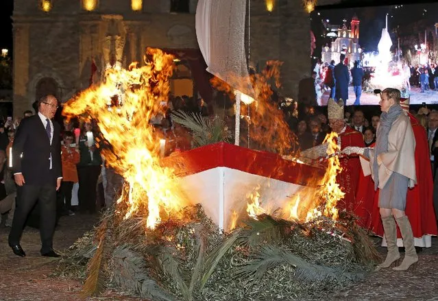 Prince Albert II of Monaco (L) and his wife Princess Charlene (R)  hold a torch to burn a small fisherman's boat during the traditional Sainte Devote celebration in Monaco, January 26, 2016. Sainte Devote, the country's patron saint, is a cherished part of Monegasque heritage. (Photo by Eric Gaillard/Reuters)