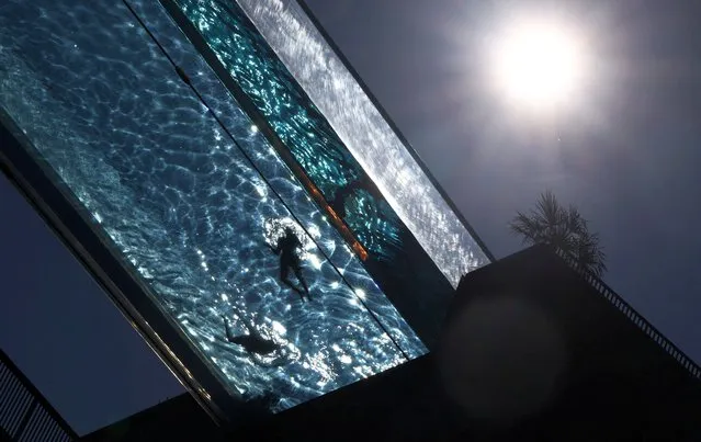 People relax in a swimming pool suspended between high-rise residential buildings at Embassy Gardens as the hot weather continues in London, Britain on September 7, 2023. (Photo by Toby Melville/Reuters)