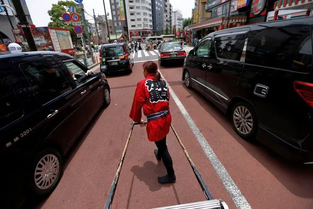 Rickshaw puller Misato Otoshi, 30, drives a rickshaw around Asakusa district in Tokyo, Japan on June 21, 2023. (Photo by Issei Kato/Reuters)
