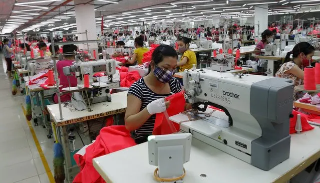 Labourers work at an assembly of Singlun Star garment factory outside Hanoi in this August 19, 2014 file photo. Vietnam is expected to report PMI numbers this week. (Photo by Reuters/Kham)