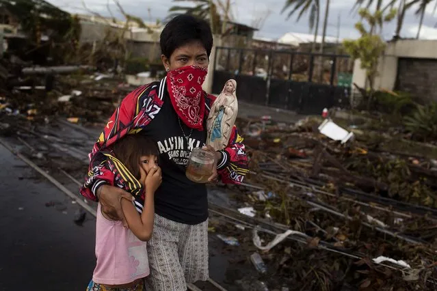 People carry their belongings through the streets of Tacloban o Tuesday. (Photo by Jes Aznar/The New York Times)