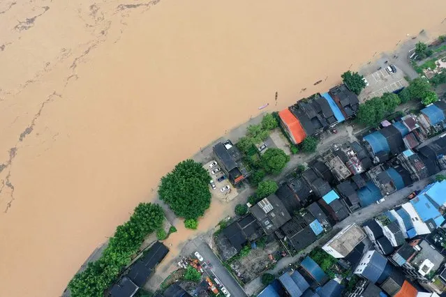 This aerial photo taken on July 2, 2021 shows a flooded street along the swollen Rongjiang river after heavy rains in Rongan, in China's southern Guangxi region. (Photo by AFP Photo/China Stringer Network)
