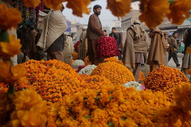 Pakistani vendors sell garlands at a flower market in Peshawar, Pakistan, Friday, December 9, 2016. (Photo by Mohammad Sajjad/AP Photo)