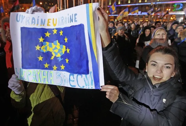 Ukrainian protesters carry a poster with a EU flag image during a mass meeting on the European square in Kiev, Ukraine, 26 November 2013. (Photo by Sergey Dolzhenko/EPA)