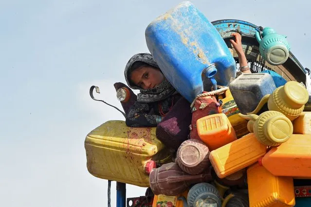 In this photo taken on November 4, 2023, an Afghan refugee girl along with her belongings arrives at the Chaman border to depart for Afghanistan. More than 180,000 people have returned to Afghanistan since Islamabad ordered 1.7 million Afghans it says are living illegally in Pakistan to leave or face deportation, border officials have said. (Photo by Banaras Khan/AFP Photo)