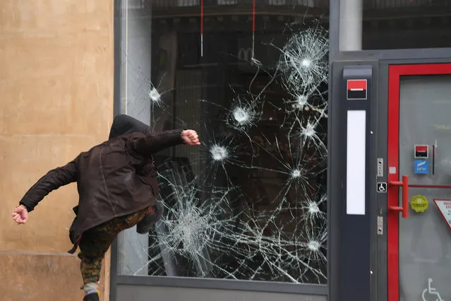 A person smashes the window of a bank a during a “Day of strikes” called by the France's General Confederation of Labour (CGT) French worker's union in the French capital Paris on February 5, 2019. (Photo by Alain Jocard/AFP Photo)