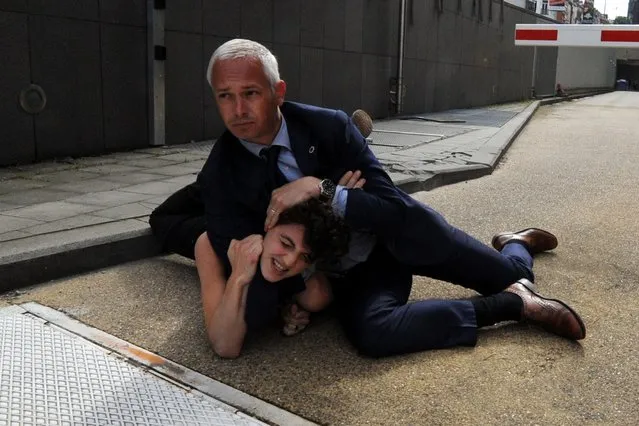 Activist Margo Frutier from the women's rights group FEMEN is detained by a security personnel after staging a protest near the European Commission during a visit by Tunisia's Prime Minister Ali Larayedh in Brussels, June 25, 2013. (Photo by Laurent Dubrule/Reuters)