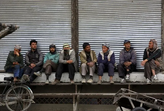 Afghan labor workers wait for customers in Kabul, Afghanistan, Sunday, April, 19, 2015. (Photo by Rahmat Gul/AP Photo)