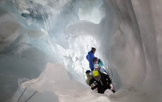 Tourists climb inside the Ice Palace glacier hollow at Hintertux glacier, located at around 3250 meters above sea level, in Zillertal, Austria, 02 March, 2016. The hollow's temperature remains constant at 0 degrees Celsius, in summer and winter alike, and is also used by the University of Innsbruck for scientific research projects. (Photo by Lisi Niesner/EPA)
