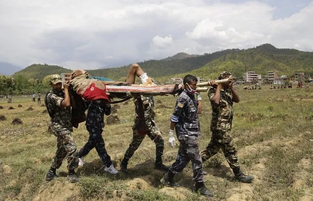 Nepalese rescuers carry a wounded man on a makeshift stretcher to a waiting Indian air force helicopter as they evacuate victims of Saturday's earthquake from Trishuli Bazar to Kathmandu airport in Nepal, Monday, April 27, 2015. (Photo by Altaf Qadri/AP Photo)