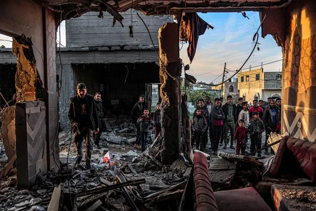 People inspect debris and rubble in a building heavily damaged by Israeli bombardment, in Rafah in the southern Gaza Strip on February 11, 2024, amid the ongoing conflict between Israel and the Palestinian militant group Hamas. (Photo by Said Khatib/AFP Photo)