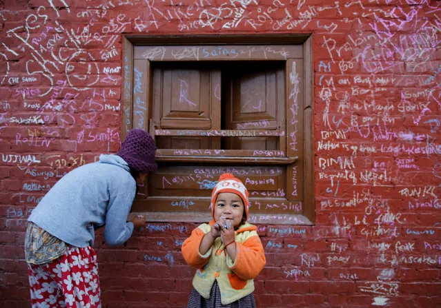 A girl (L) writes on a wall of Saraswati temple to mark Shreepanchami festival in Kathmandu, Nepal February 1, 2017. (Photo by Navesh Chitrakar/Reuters)