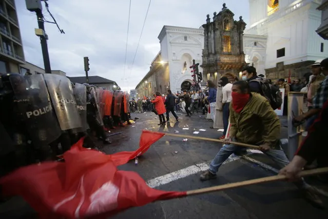 Protesters clash with police blocking them from advancing closer to the presidential palace in Quito, Ecuador, Tuesday, April 16, 2019. Protesters were demonstrating against the policies of President Lenin Moreno's government, including the recent firing of state workers, the taking of an IMF loan and the removal of Julian Assange's asylum status. (Photo by Dolores Ochoa/AP Photo)