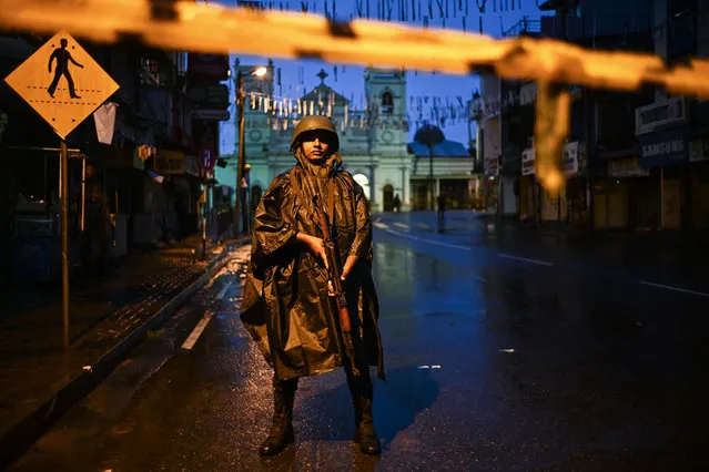 A soldier stands guard under the rain at St. Anthony's Shrine in Colombo on April 25, 2019, following a series of bomb blasts targeting churches and luxury hotels on the Easter Sunday in Sri Lanka. Sri Lanka's Catholic church suspended all public services over security fears on April 25, as thousands of troops joined the hunt for suspects in deadly Easter bombings that killed nearly 360 people. (Photo by Jewel Samad/AFP Photo)