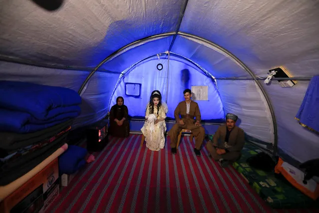 Iraqi newlyweds, who fled Mosul, Hussain Zeeno Zannun (R), 26, and Chahad, 16, sit inside their tent during their wedding party at Khazer camp in Iraq February 16, 2017. (Photo by Zohra Bensemra/Reuters)