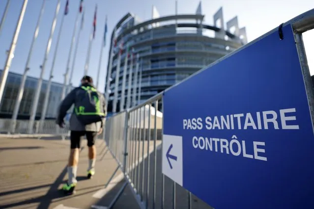 A man walks to the Health Pass control zone outside the European Parliament in Strasbourg, eastern France, Wednesday, November 24, 2021. Infections and virus-related hospitalizations and deaths are on the rise in France in recent weeks, and the government is stepping up enforcement of the health pass and encouraging people to get booster shots. (Photo by Jean-Francois Badias/AP Photo)